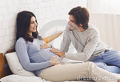 Loving husband stroking pregnant belly of his wife Stock Photo