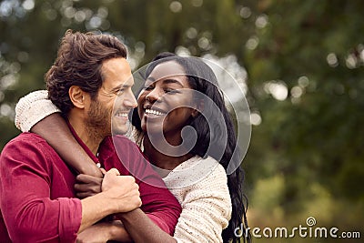 Loving Mixed Race Couple Leaning On Fence On Walk In Countryside Stock Photo