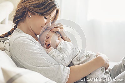 Loving mom carying of her newborn baby at home Stock Photo