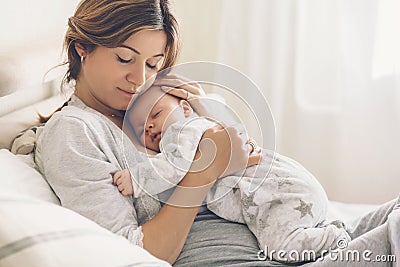 Loving mom carying of her newborn baby at home Stock Photo