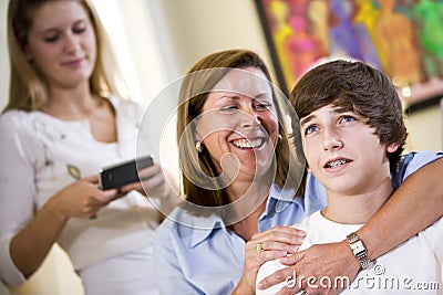 Loving mother with arm around teenage son Stock Photo