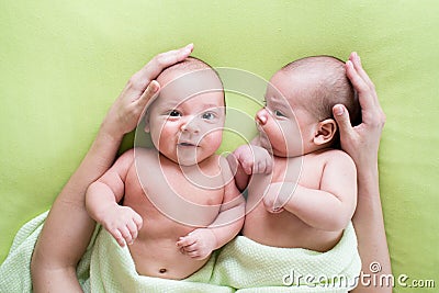 Loving mother hands embrace twins babies Stock Photo