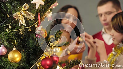 Loving parents helping their daughter to decorate Christmas tree, magic moments Stock Photo