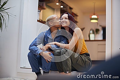 Loving Same Sex Female Couple Hugging And Kissing As They Relax At Home Together Stock Photo