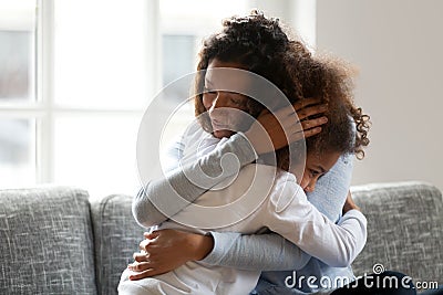 Loving single black mother hugging african daughter caressing cu Stock Photo