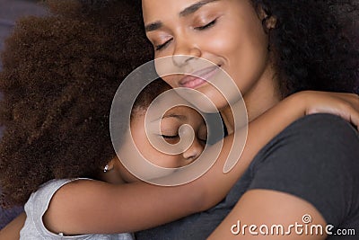 Loving single black mother hugs cute daughter feel tenderness connection Stock Photo