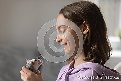 Loving teenage girl play with cite domesticated mouse at home Stock Photo