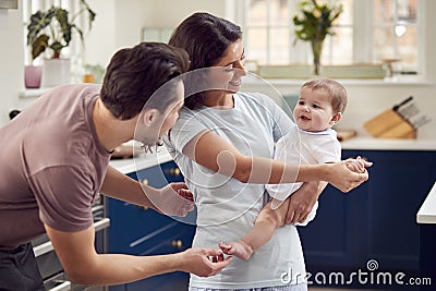 Loving Transgender Family With Baby In Kitchen At Home Together Stock Photo