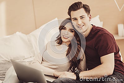 Loving wife lying near her industrious smart businessman in bedroom Stock Photo