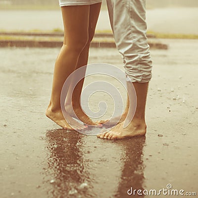 A loving young couple hugging and kissing under a rain. Lovers m Stock Photo