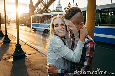 Loving young couple is hugging during the sunset in the street. Emotional close-up portrait. Stock Photo