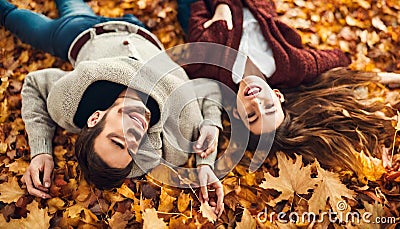 A loving young couple lying on autumn leaves, enjoying a beautifu Stock Photo