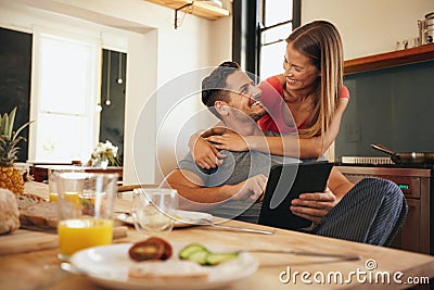 https://thumbs.dreamstime.com/x/loving-young-couple-morning-shot-kitchen-breakfast-table-man-using-digital-table-women-hugging-him-behind-57808261.jpg