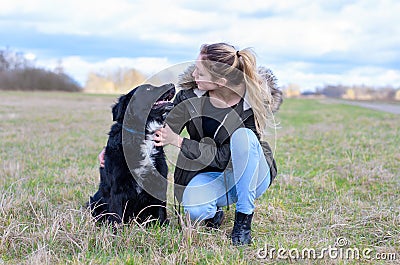 Loving young woman with her loyal black dog Stock Photo