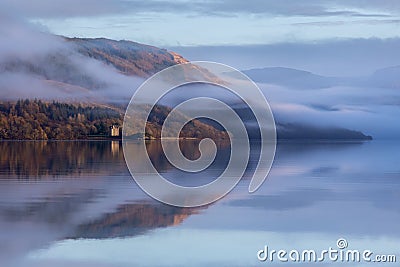 Low-angle of Dunderave castle on the foogy shores of the picturesque Loch Fyne, Scotland Stock Photo