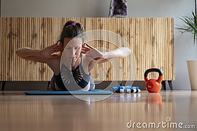 Low angle fron view of a young woman lying on a mat working out doing a back lift exercise Stock Photo