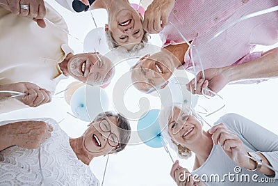 Low angle of happy senior people in the circle with balloons Stock Photo