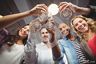 Low angle portrait of cheerful colleagues toasting in office Stock Photo