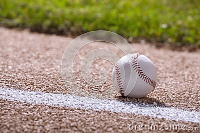 Low angle selective focus view of a baseball on a basepath in sunlight Stock Photo