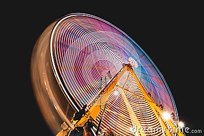 Low angle shot of an abstract spinning Ferris wheel with a black background Stock Photo