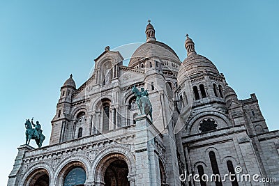 Low angle shot of The Basilica of the Sacred Heart of Paris under a blue sky in France Editorial Stock Photo