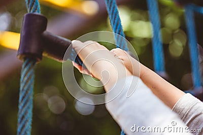 Low angle shot of a child holding on to a blue climbing toy on the playground of a park Stock Photo