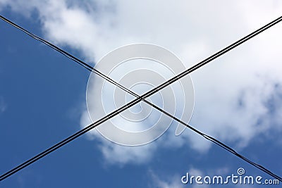 Low angle shot of crossed wires under the cloudy sky Stock Photo