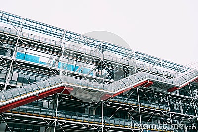 Low angle shot of a metal structure with a glass stairway in front of it under the bright sky Editorial Stock Photo