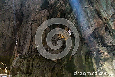 Low angle shot of a pit cave and a buddha statue with sun rays falling inside Stock Photo