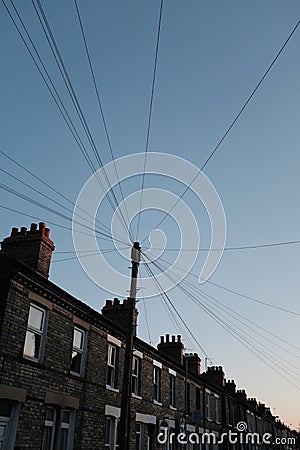 Low angle shot of a post with lots of wires on old buildings background Stock Photo