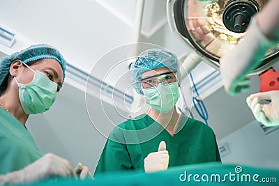 Low Angle Shot of Professional surgeons team performing surgery in operating room, surgeon, Assistants, and Nurses Performing Stock Photo