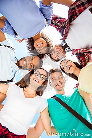 Low angle shot of six international students with toothy smiles, posing and bonding, on a sky background. Cheerful, smart and Stock Photo