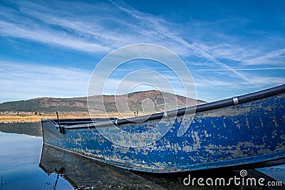 Low angle small blue abandoned fishing boat Stock Photo