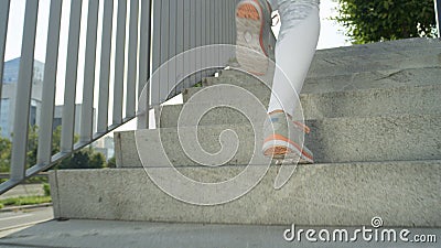 LOW ANGLE: Unrecognizable female jogger runs up a flight of concrete stairs. Stock Photo