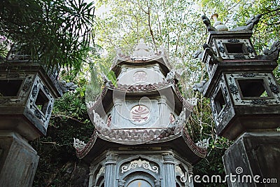 low angle view of ancient traditional oriental temple between green plants, Da Stock Photo