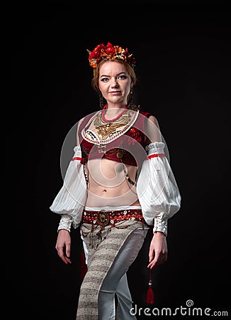 Beautiful woman in traditional folk slavic costume for belly dance and trible with wreath, vest, skirt, sleeves and necklace Stock Photo