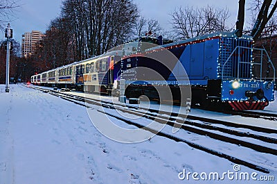 Low-angle view of Christmas decorated train by lights. Train arrived at the station Editorial Stock Photo