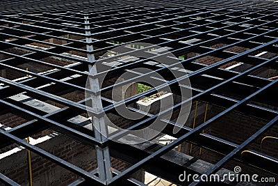 Low angle view of metal structure of roof at the construction site with bricklayers wall below Stock Photo