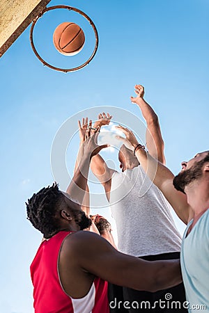 low angle view of multicultural basketball players struggling to Stock Photo