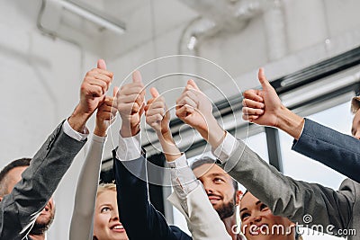 low angle view of smiling businesspeople showing thumbs up Stock Photo