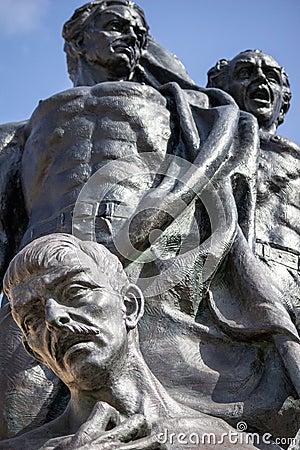 Low-angle view of the statue of three men under the blue sky. Stock Photo