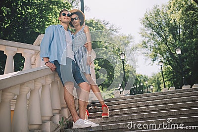 low angle view of stylish multicultural couple standing on stairs Stock Photo