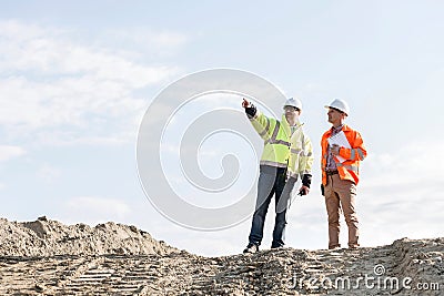 Low angle view of supervisor showing something to colleague at construction site Stock Photo