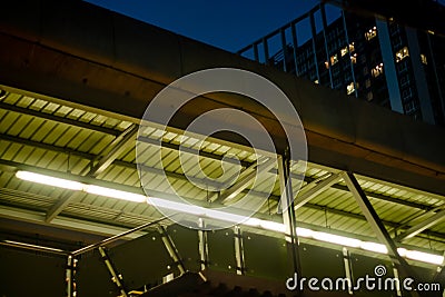 Low angle view of walkway overpass and condominium in the night. Stock Photo