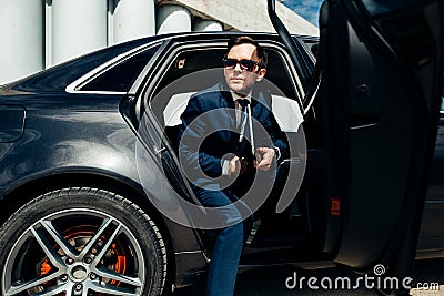 Fashionable businessman coming out of a car Stock Photo