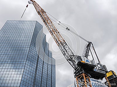 Low focus of a building in downtown Bellevue in Washington, with a crane next to it, on a cloudy day Editorial Stock Photo