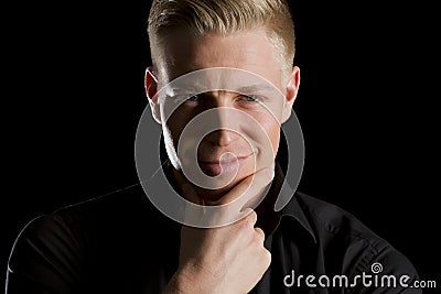 Low key portrait of smiling charming man looking straight. Stock Photo