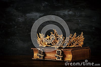low key image of beautiful queen/king crown on old book. vintage filtered. fantasy medieval period. Stock Photo