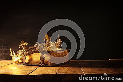 low key of queen/king crown on old book. vintage filtered. fantasy medieval period Stock Photo