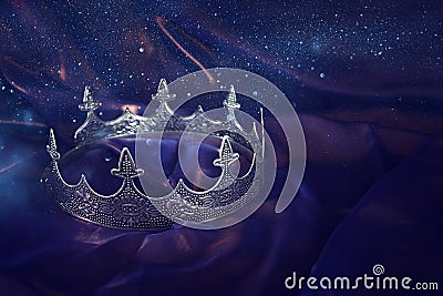 Low key image of beautiful queen/king crown over dark royal purple delicate silk. fantasy medieval period Stock Photo